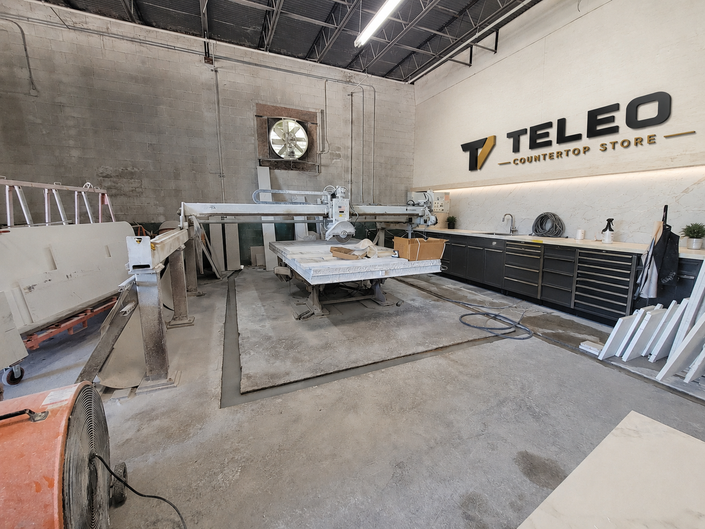 Teleo Countertops fabrication shop with CNC bridge saw and branded wall sign